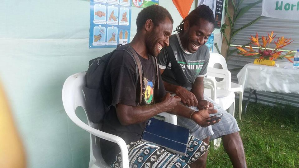 Photo of two ni-Vanuatu youth boys on the remote island of Tanna playing Rispek Danis (The Respect Dance) a serious video game about consent.