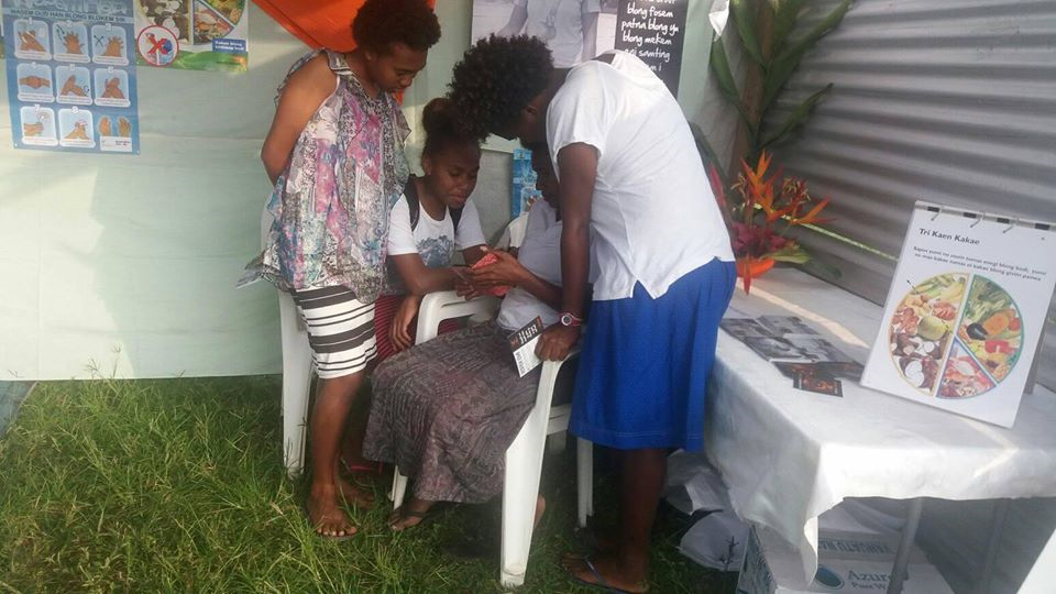 Photo of ni-Vanuatu youth learning from a World Vision Staff Member about Rispek Danis (The Respect Dance) a serious video game about consent.